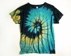 a blue and yellow tie - dyed t - shirt hanging on a white hanger