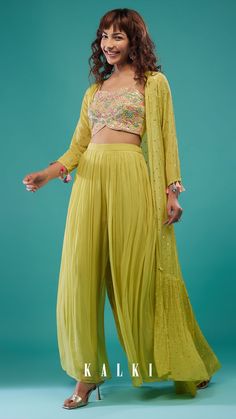 "An elegant celery green mirror work embroidered palazzo set in georgette. The embroidered crop top is crafted with a sweetheart neckline, spaghetti sleeves, and a back hook closure. Paired with a chic long open shrug with sequins embroidered on it and three-forth sleeves with tassels on the cuff. The flared palazzo comes with an elastic waistband and a side zip closure." Western Dresses For Wedding, Western Dresses Online, Indo Western Dresses, Indo Western Dress, Lehenga Choli Online