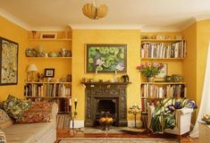 a living room filled with furniture and bookshelves next to a fire place under a painting