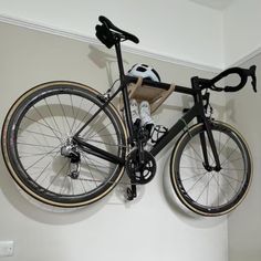 a bicycle mounted to the wall with a helmet on it