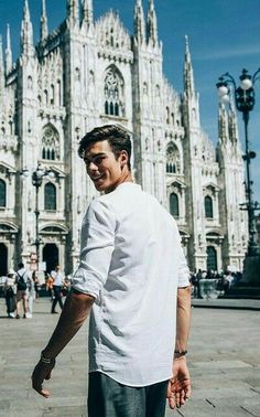 a man standing in front of a large cathedral