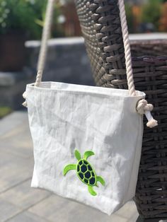 "Who doesn't love an adorable sea turtle! Pick from a variety of colors and two handle styles! Vintage sails upcycled into one-of-a-kind totes! Each bag is handcrafted from a variety of available sails so no two totes are exactly alike. Weathering of the sails bestows characteristics unique to each bag. Sail seams and seam placement will vary among bags. Featuring our new embroidered sea turtle design, this bag measures approximately 10\"h x 12\"w x 4\"d and includes two open interior pockets. A Upcycled Beach Tote Bag, Upcycled Tote Bag For Beach, Everyday Sail-colored Rectangular Bag, Nautical Bags, Eco-friendly Upcycled Beach Bags, Nautical Tote Beach Bag, White Nautical Canvas Bag, Nautical Sail-colored Bag For Daily Use, Recycled Sails