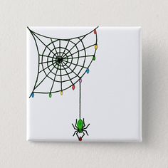 a spider web with christmas lights hanging from it's side on a white button