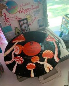 an old record with mushrooms on it sitting on a table next to a sign that says happy tunes