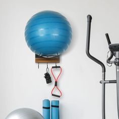 there is a blue exercise ball on the wall next to an exercise bike and gym equipment