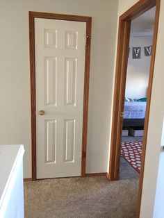 an open door leading to a bedroom with a red and white checkered rug on the floor