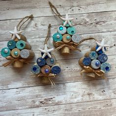 three ornaments made out of shells and seashells are sitting on a wooden surface