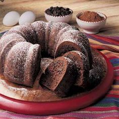 a bundt cake sitting on top of a red plate next to eggs and spices