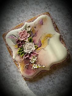 a decorative plate with flowers on it sitting on top of a wallpapered surface