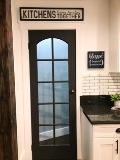 a kitchen with a black door and white cabinets