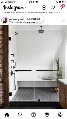 a bathroom with a walk in shower next to a brick wall and tiled flooring