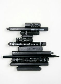 a group of pens sitting on top of each other in front of a white background