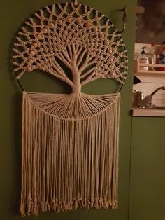 a macrame wall hanging with a tree on it