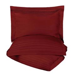 a bed with red sheets and pillows on top of it, in front of a white background