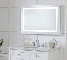 a white bathroom vanity with a mirror above it