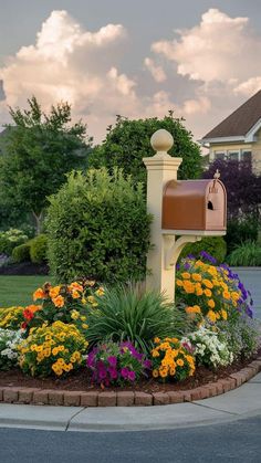 a mailbox sitting in the middle of a flower bed