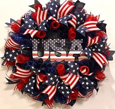 a wreath with red, white and blue ribbons on it that says usa in the center