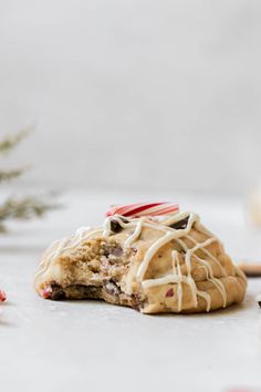 a cookie with white icing on it sitting next to candy canes and christmas decorations