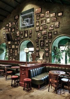 the interior of a restaurant with green walls and pictures on the wall behind the booths