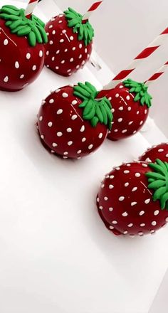 three chocolate covered strawberries sitting on top of a white box with red and green decorations