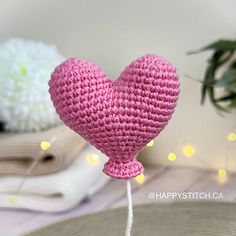 a pink crocheted heart sitting on top of a table