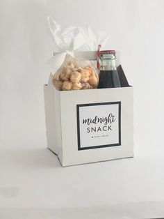 a white box filled with food and drinks on top of a white tablecloth covered floor