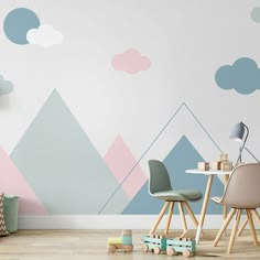 a child's room with mountains and clouds painted on the wall, along with toys