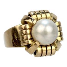 A fine French Art Deco period cocktail ring.   In 18k yellow gold.  Prong set with a large ca. 9 mm off-round, slightly baroque white pearl in a shaped setting.  Hallmarked on the band with a French 'owl' import mark (that is partially rubbed).  Simply a wonderful Deco Period ring!  Date: 20th Century  Overall Condition: It is in overall good, as-pictured, used estate condition with some very fine & light surface scratches and other signs of expected light wear consistent with age.  Fineness: Un Pearl Cocktail Ring, Art Deco Period, French Art Deco, Turquoise Rings, Put A Ring On It, French Art, Pearl Size, Gold Pearl, Cocktail Ring