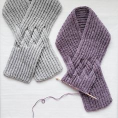 two knitted scarves sitting next to each other