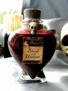 there is a bottle with a skull on it in the shape of a heart that says blood of the unidentifiable