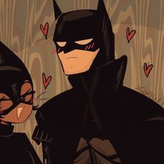 batman and catwoman standing next to each other with hearts on the wall behind them