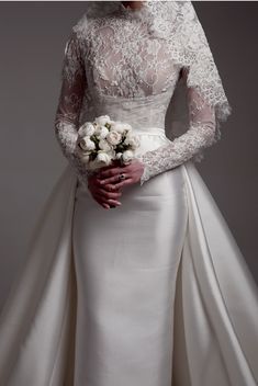 a woman in a wedding dress holding flowers