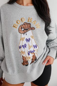 The Boo Haw Sequin Sweatshirt is a fun and festive piece that adds a playful touch to your casual wardrobe. Made from soft, cozy fabric, this sweatshirt ensures comfort and warmth for those chilly days. The heather grey background provides a versatile base, while the whimsical ghost graphic adorned with shimmering sequins and the cheeky "Boo Haw" message create a standout look that's perfect for Halloween or adding a bit of festive flair year-round. The relaxed fit and classic crew neckline make Fall Holiday Cotton Sweatshirt, Cotton Sweatshirt For Fall Holiday, Relaxed Fit Holiday Sweatshirt For Fall, Ghost Graphic, Kimono Outerwear, Sequined Sweatshirt, Fall Flannel, Casual Bodysuit, Brunch Dress