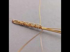 a close up of a piece of gold wire with some thread on top of it