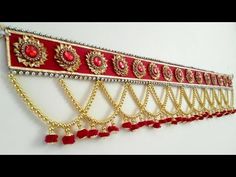 a red and gold wall hanging with tassels