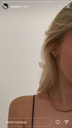 a woman with blonde hair wearing a gold necklace