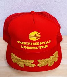 a red and gold hat with the words continental commuter on it sitting on a wooden table