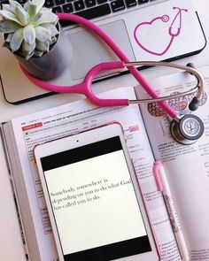 an open book with a stethoscope on top of it next to a laptop