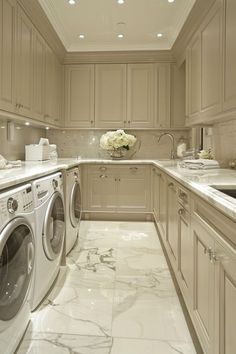 a washer and dryer in a very large kitchen with marble counter tops on the floor