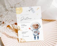 a baby's first birthday card with an astronaut on the front, and a pine tree in the background