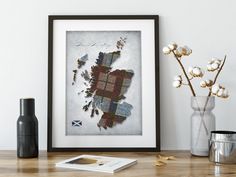 a framed photograph sitting on top of a wooden table next to a vase filled with flowers