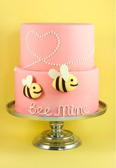 a pink cake with two bees on top and the words bee mine written on it