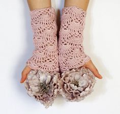 a pair of pink gloves with crocheted flowers on the thumbnails are shown