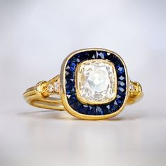 an antique diamond and blue sapphire ring with two diamonds on each side, set in yellow gold