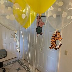 winnie the pooh and tigger balloons in front of a door