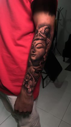 a man with a buddha tattoo on his arm