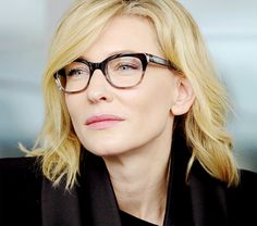 a close up of a person wearing glasses and looking off to the side with a serious look on their face