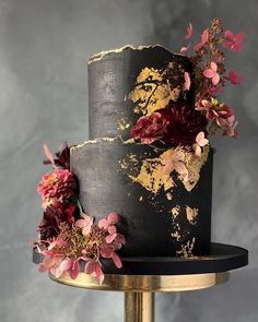 a black and gold wedding cake with flowers on the top is featured in an instagram