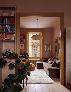 a living room filled with lots of furniture and bookshelves next to a window