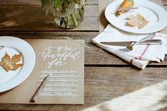 the table is set with plates, napkins and place settings for an autumn dinner